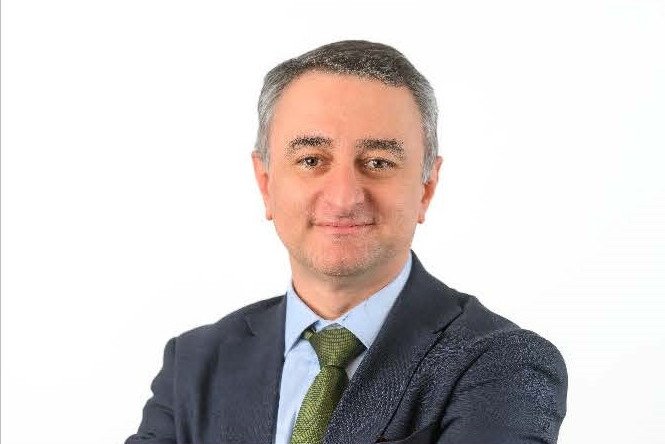 Portrait Vinicus mit grauem Anzug und grüner Krawatte