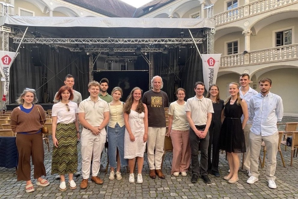 Studierende und Dozierende der Universität Passau vor der Inszenierung der Kammeroper „Die wunderbaren Jahre“ am Theater Regensburg mit dem Komponisten Torsten Rasch (7. v. r.) und der Regisseurin Sabine Sterken (6. v. r.).