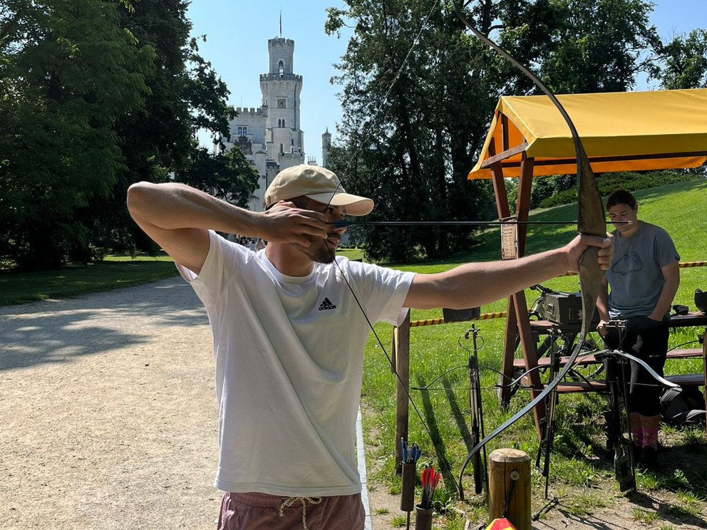Mann zeigt mit Pfeil und Bogen 