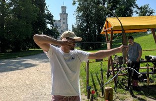 Mann zeigt mit Pfeil und Bogen