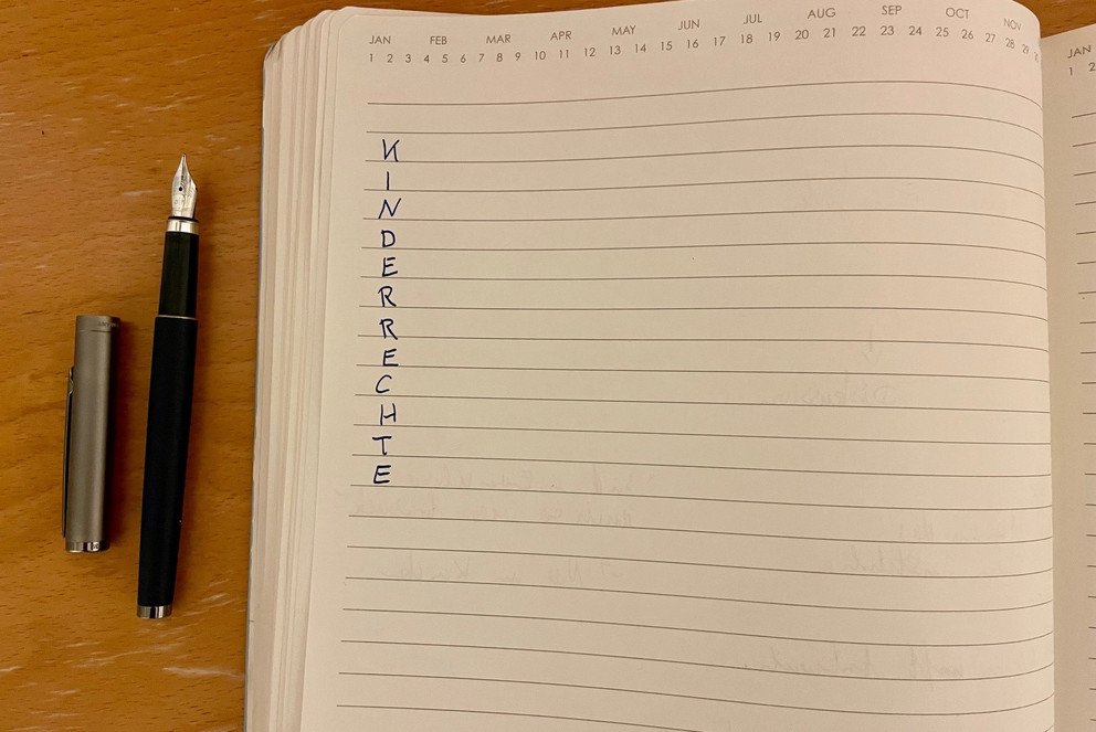 Auf einem Notizbuch, sind Kinderrechte vertikal geschrieben