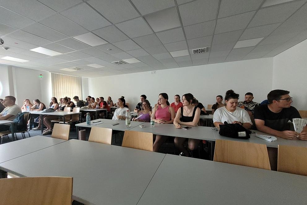 Gruppe sitzt in einem Seminarraum