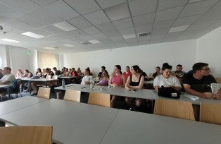 Gruppe sitzt in einem Seminarraum