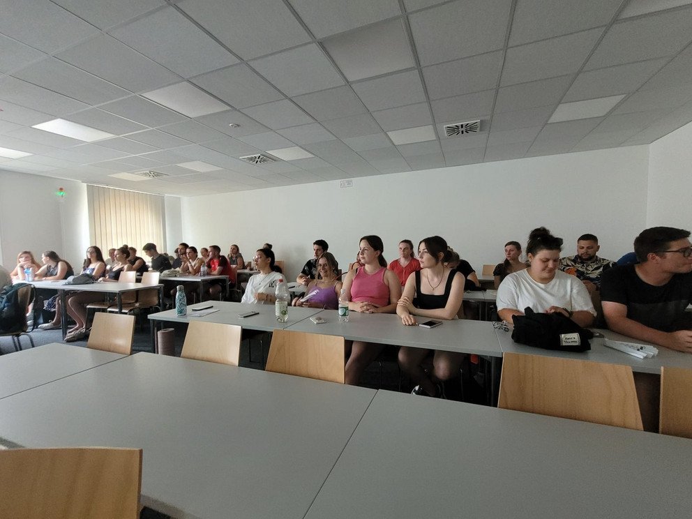 Gruppe sitzt in einem Seminarraum