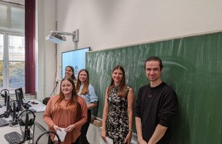 Gruppe Studierender vor Schultafel