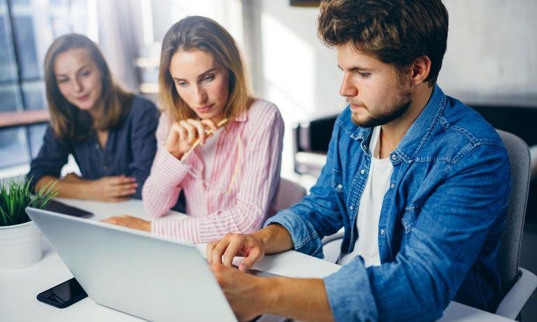 Digitale Gruppenarbeit mit drei Studierenden vor Laptop