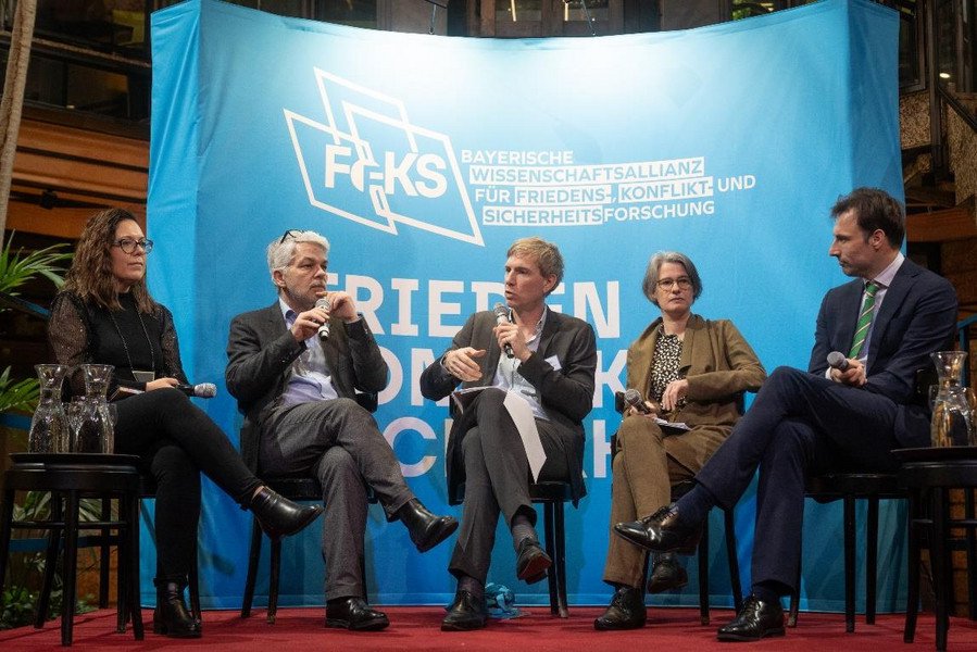 Prominent besetztes Podium: v.l.: Branka Panic (AI for Peace), Prof. Dr. Carlo Masala (Universität der Bundeswehr München, FoKS-Fellow), Prof. Dr. Stephan Stetter (Universität der Bundeswehr München, Co-Sprecher FoKS), Prof. Dr. Katrin Kinzelbach (Friedrich-Alexander-Universität Erlangen-Nürnberg, FoKS-Fellow) und Dr. Max Smeets (Center for Security Studies (CSS) der ETH Zürich); Foto: FoKS